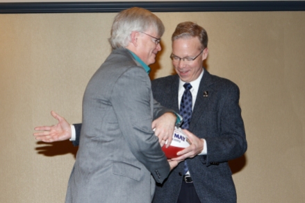 Beat Write of the Year Tim May of the Columbus Dispatch receives a commemorative football from Malcolm Moran. Photo by Melissa Macatee.